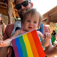 Man with equal rights flag and child